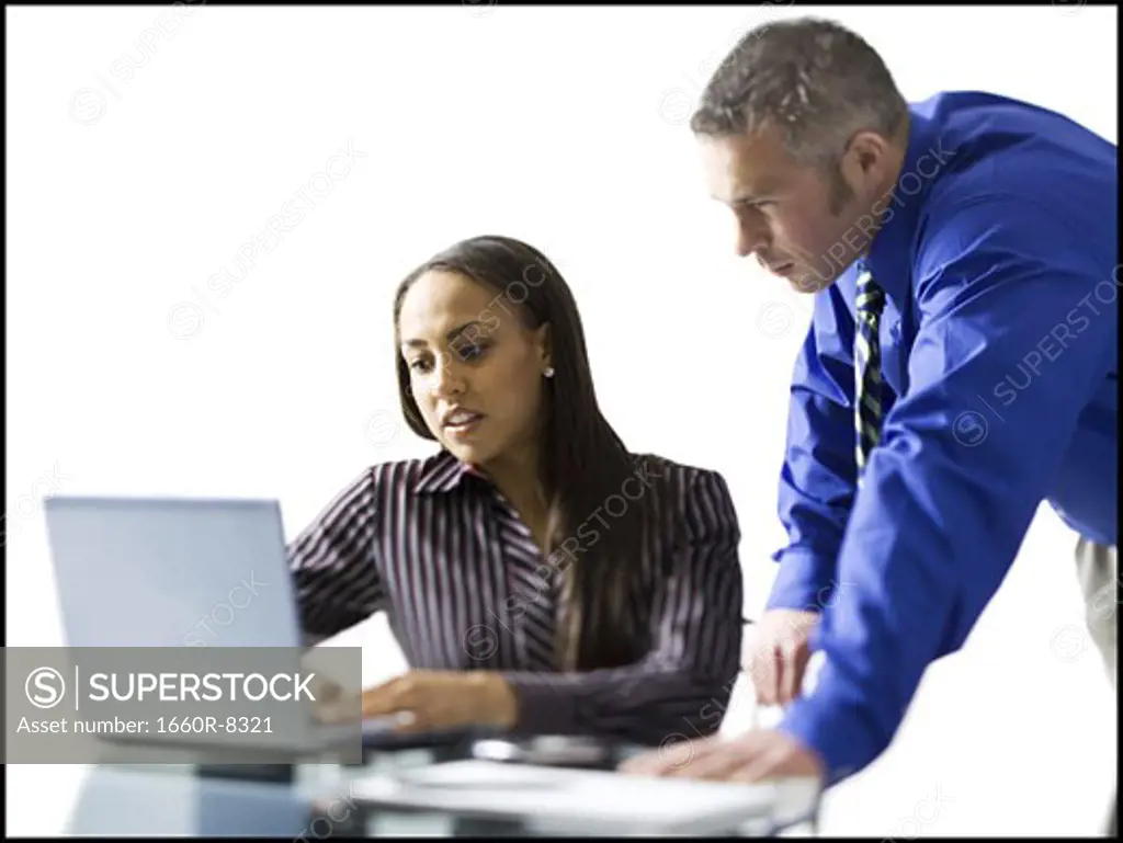 Businesswoman and a businessman working on a laptop