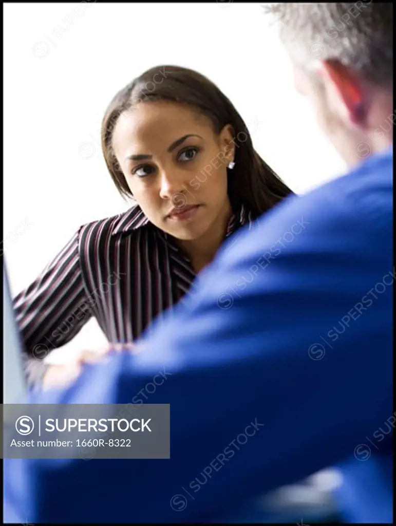 Close-up of a businesswoman looking at a businessman