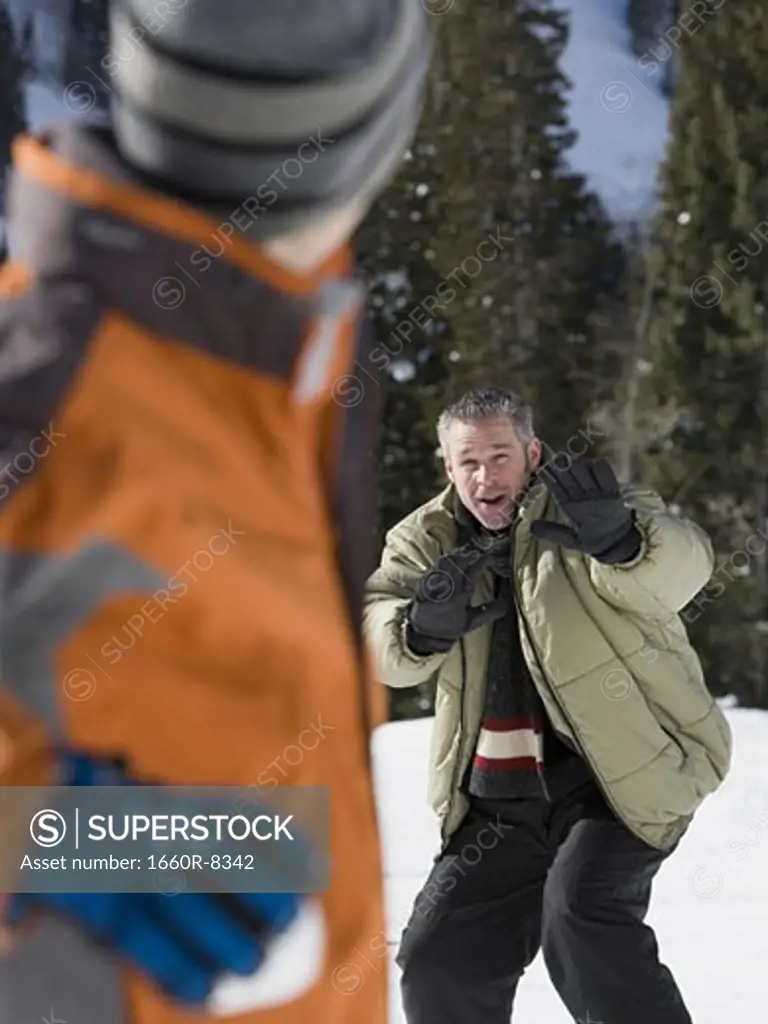 Close-up of a father and his son playing with snowballs
