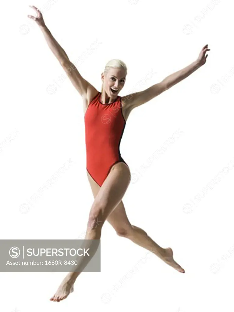 Portrait of a young woman jumping with her arms outstretched