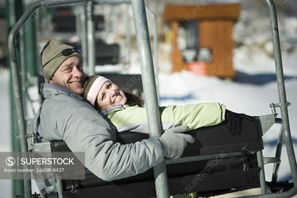 Portrait of an adult couple sitting on a ski lift