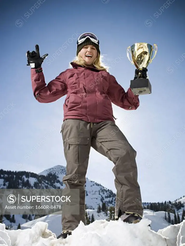 Low angle view of a young woman holding a trophy