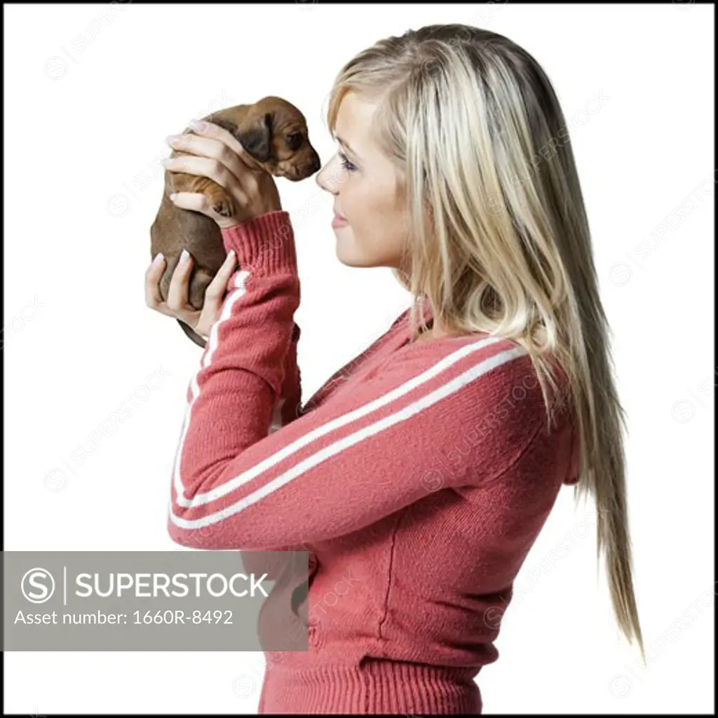 Profile of a young woman holding a puppy