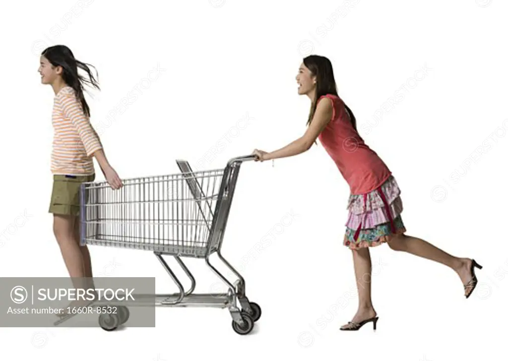 Profile of a young woman pushing a teenage girl in a shopping cart
