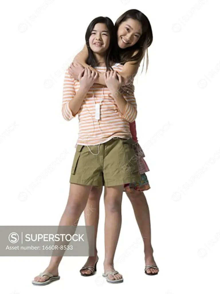Portrait of a young woman hugging a teenage girl