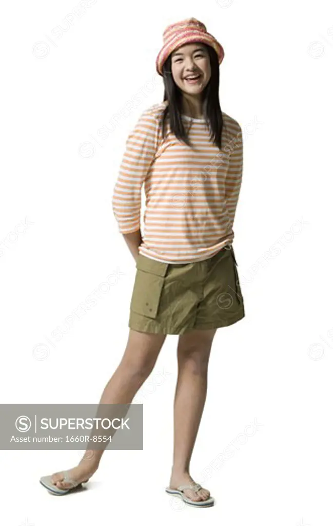 Portrait of a teenage girl standing with her hands behind her back