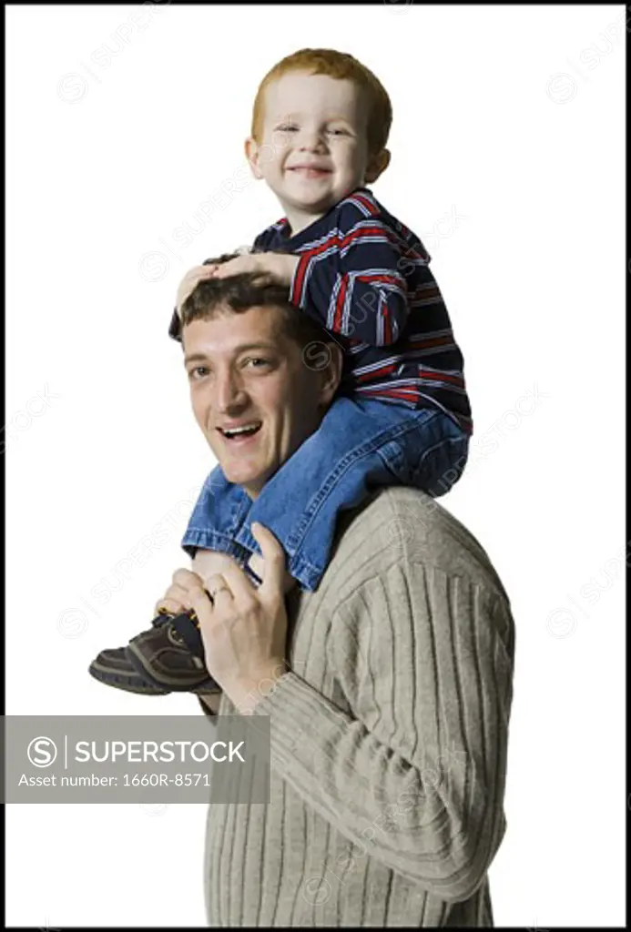 Profile of a father carrying his son on his shoulders