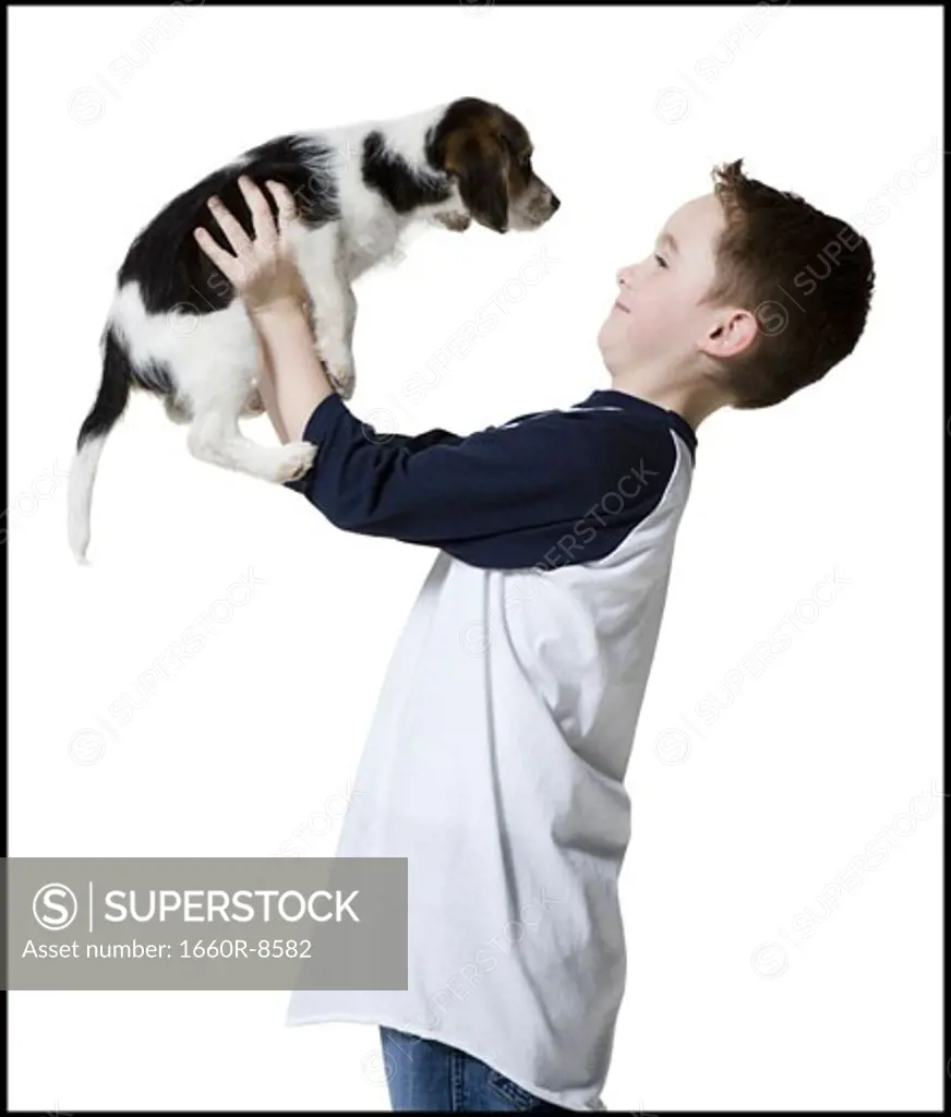 Profile of a boy holding a puppy