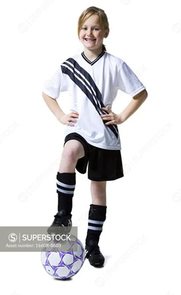 Portrait of a girl standing with her foot on a soccer ball