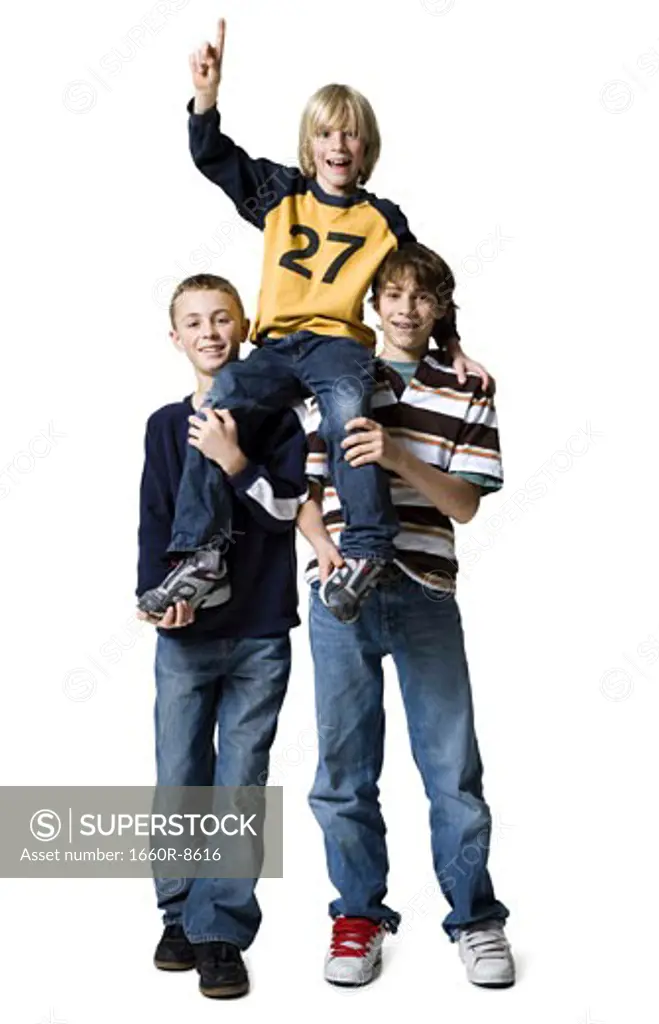 Portrait of two boys carrying a boy on their shoulders