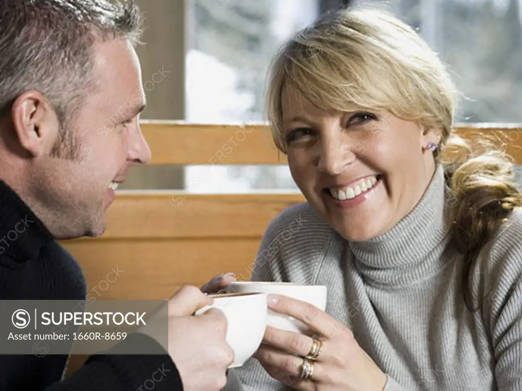 Close-up of an adult couple drinking hot beverages