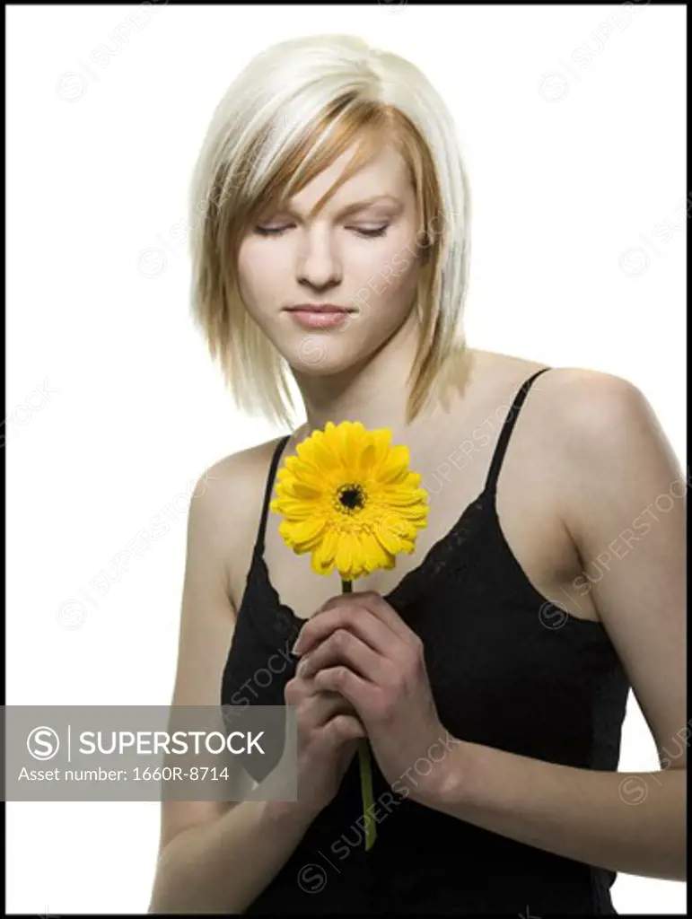 Close-up of a young woman looking at a flower