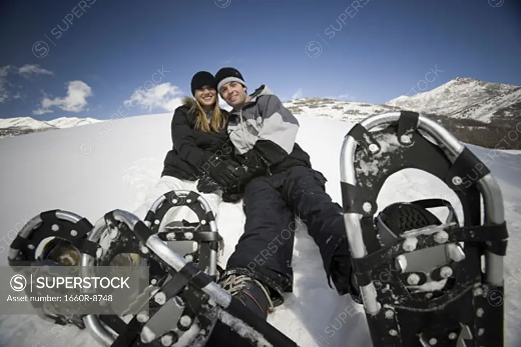 Portrait of a young couple wearing snowshoes