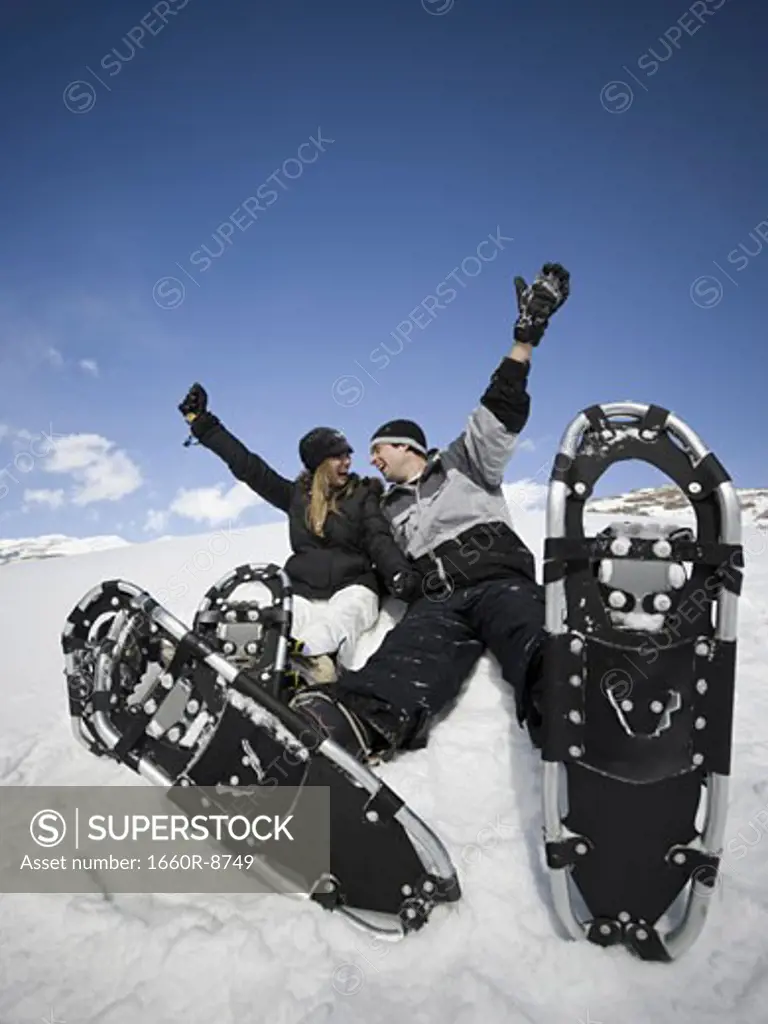 Low angle view of a young couple wearing snowshoes