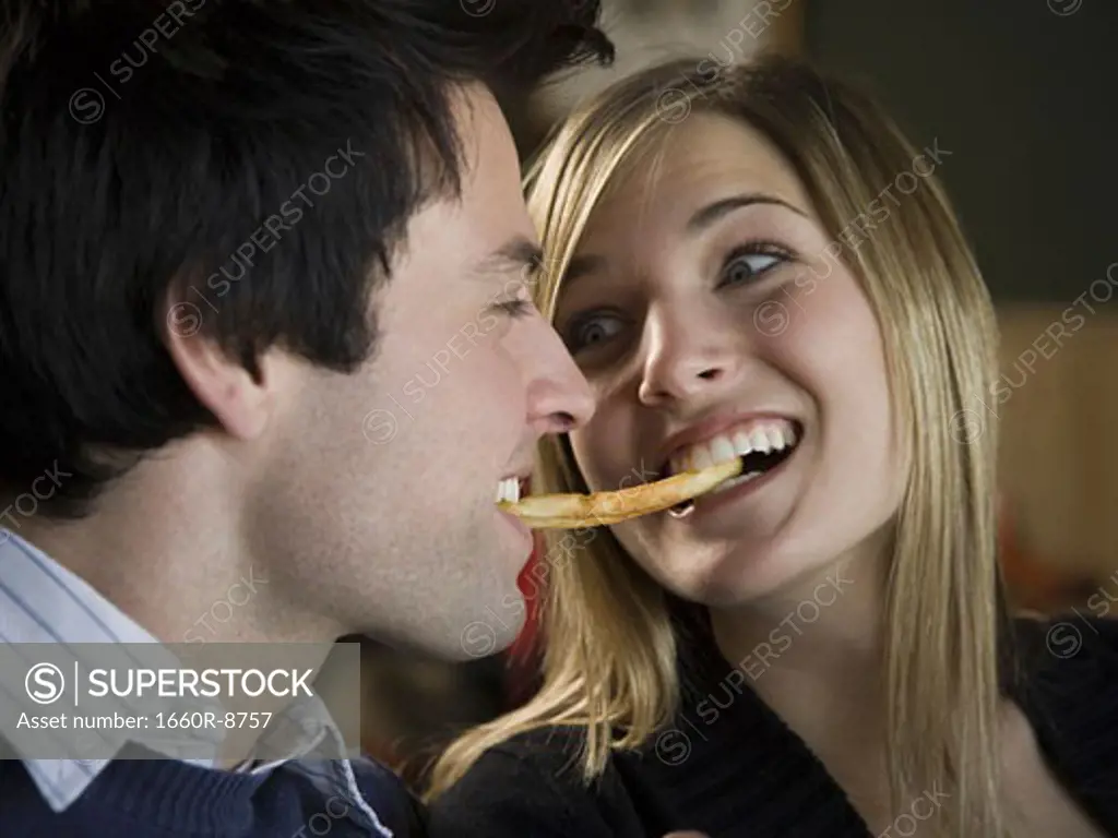 Close-up of a young couple sharing a french fry