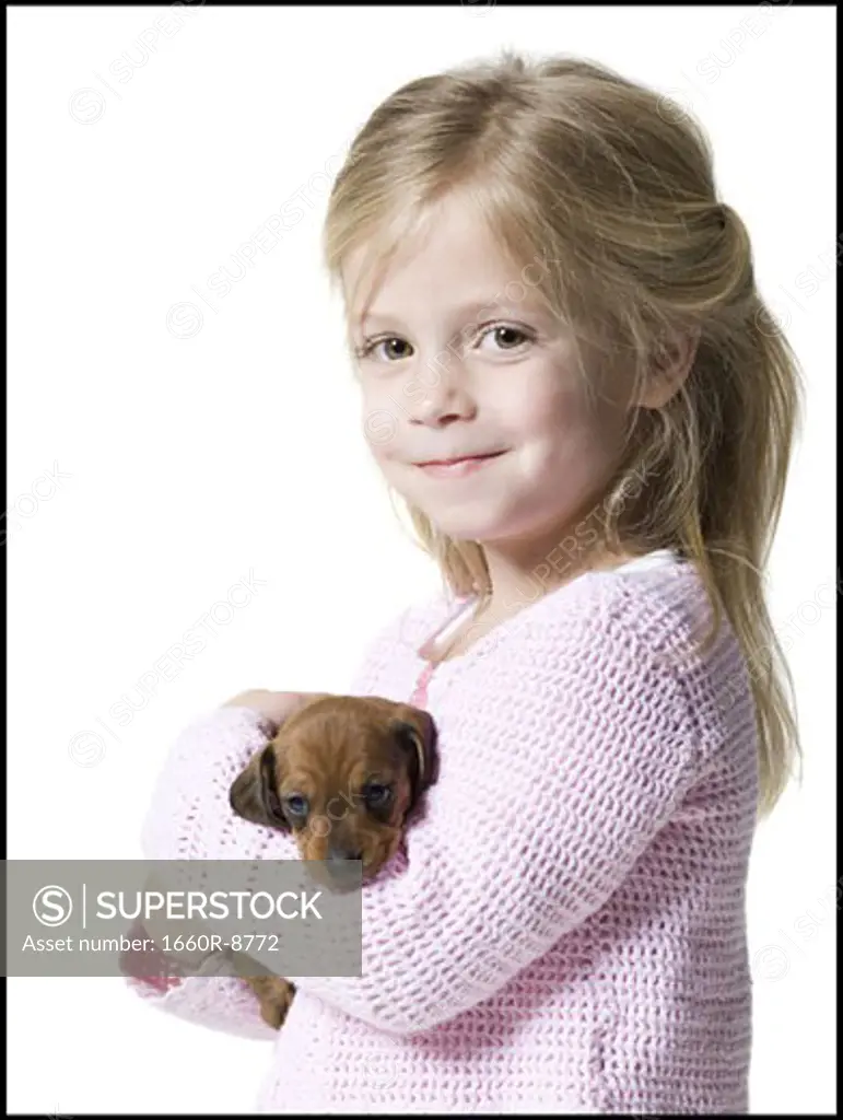 Portrait of a girl holding a dachshund puppy