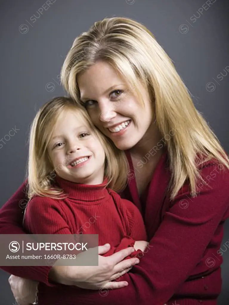 Portrait of a young woman embracing her daughter