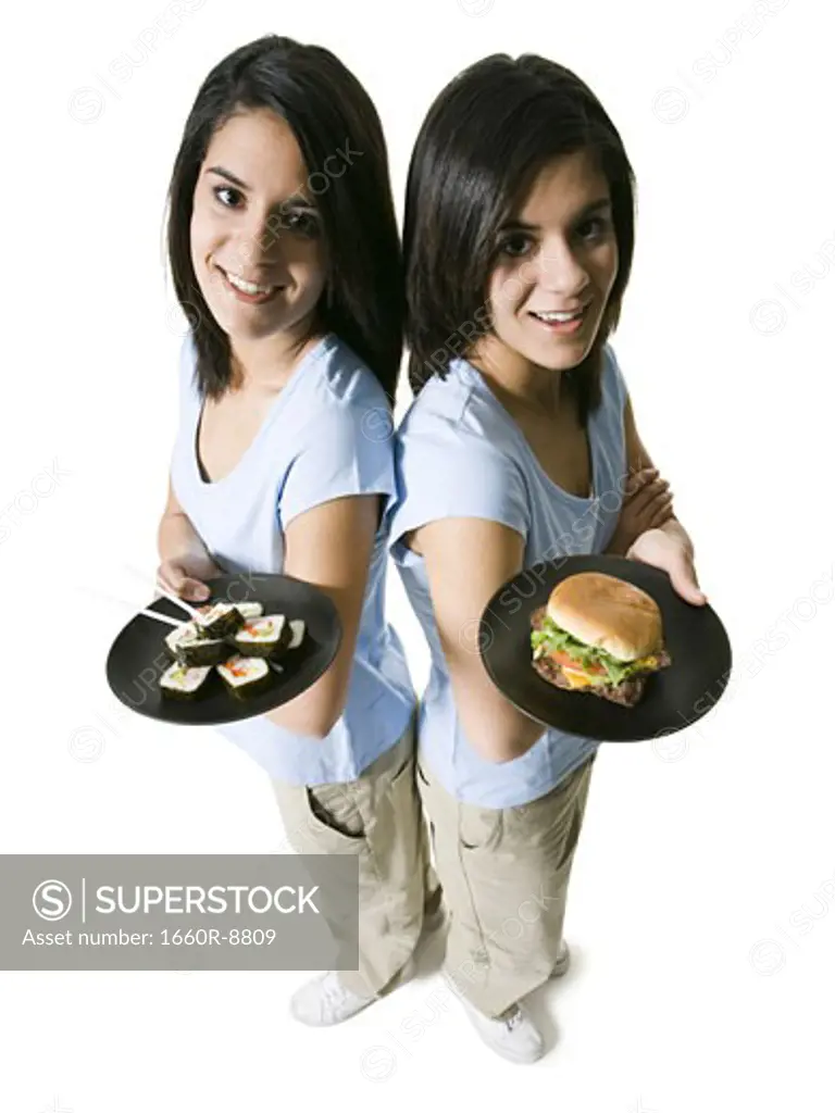 High angle view of two teenage girls holding plates of food