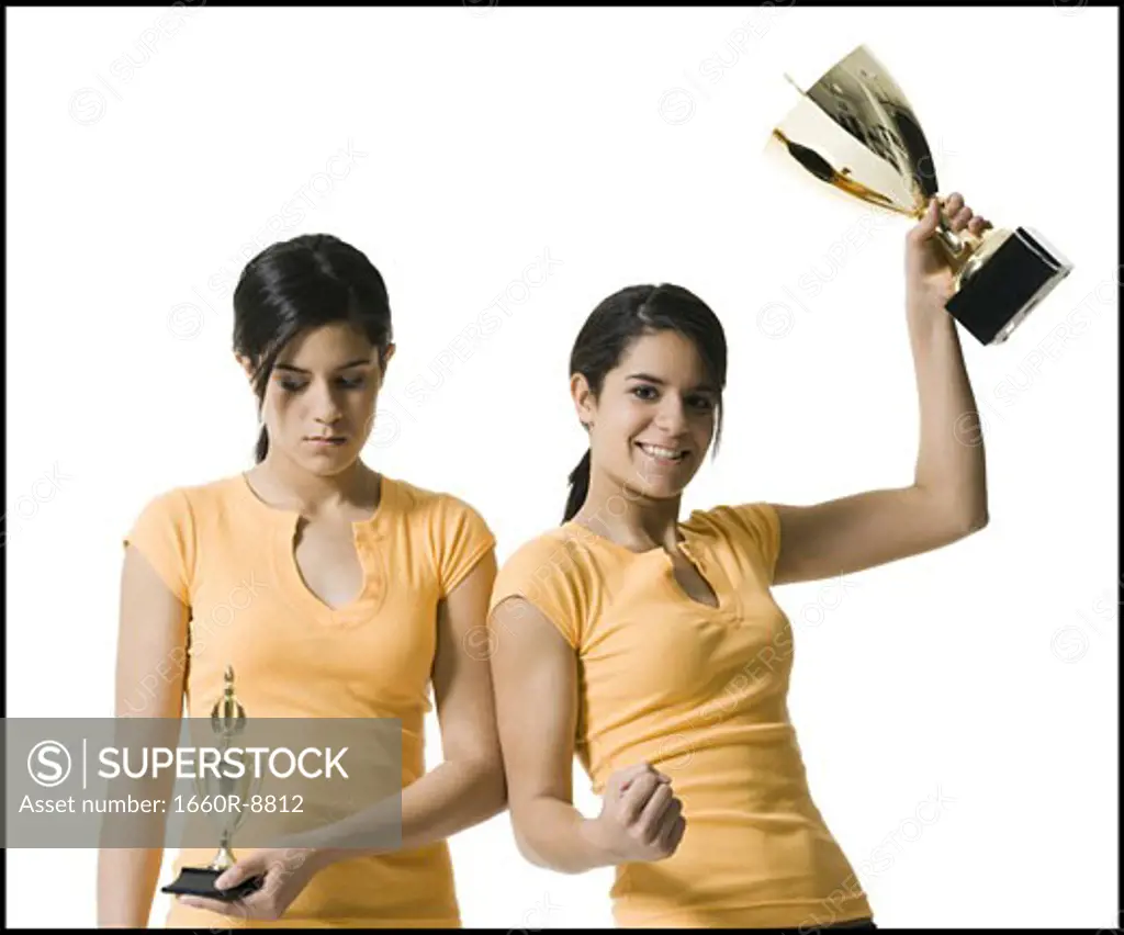 Close-up of two teenage girls holding trophies