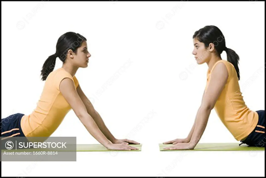 Profile of two teenage girls in a yoga position