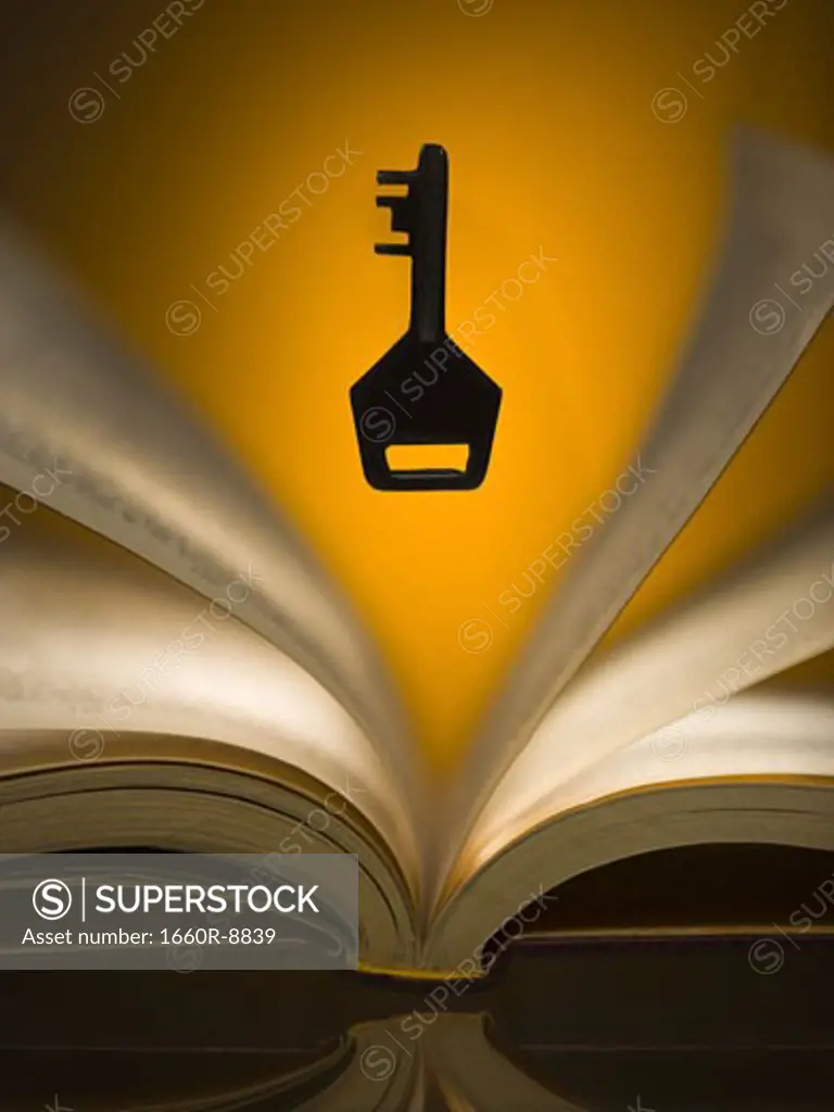 Close-up of a key hovering over a book