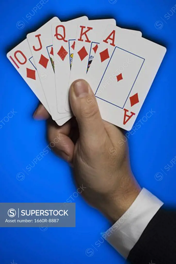 Close-up of a person's hand with a royal flush