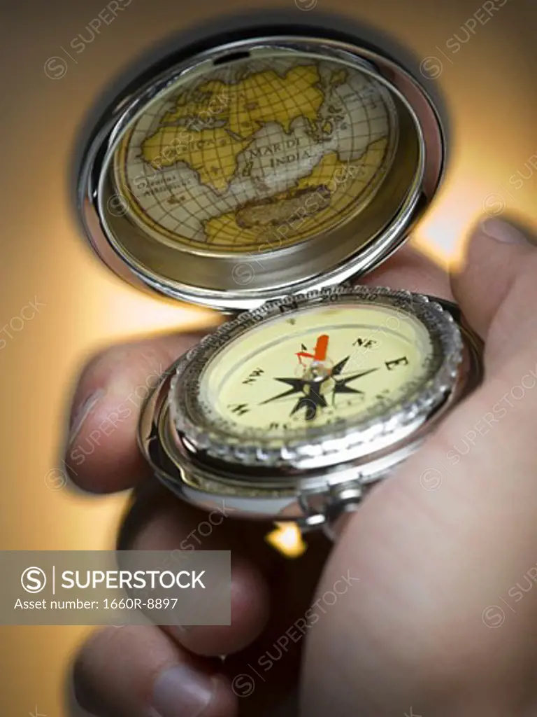 Close-up of a person's hand holding a compass