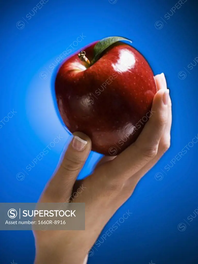 Close-up of a woman's hand holding an apple