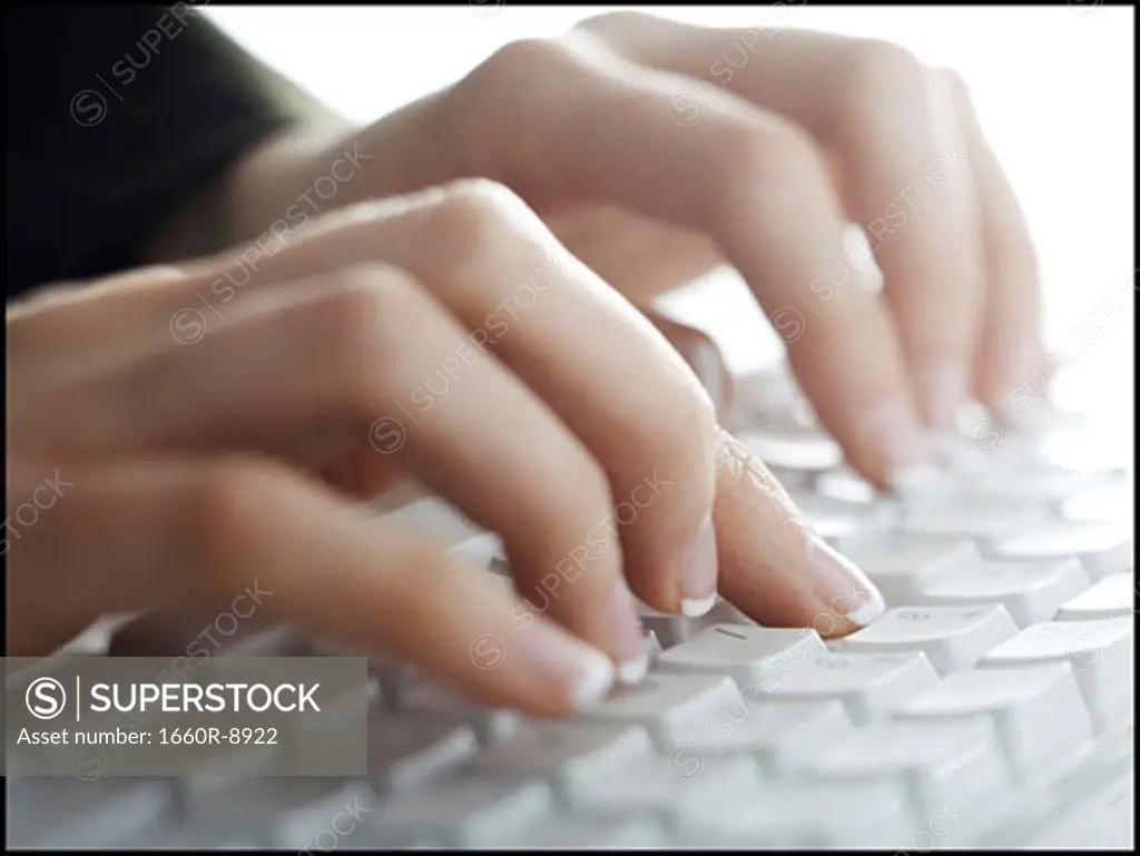 Close-up of a woman's hand typing on a computer keyboard