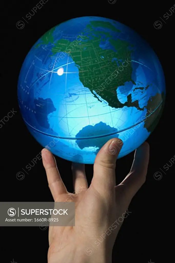 Close-up of a man's hand holding a globe