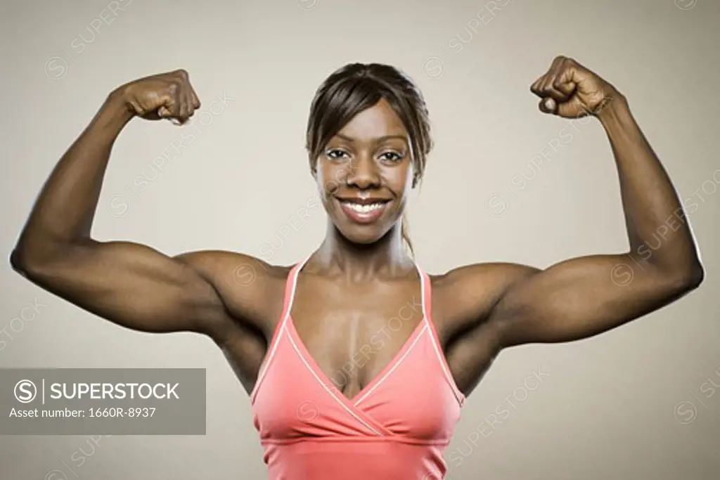 Portrait of a young woman flexing her muscles