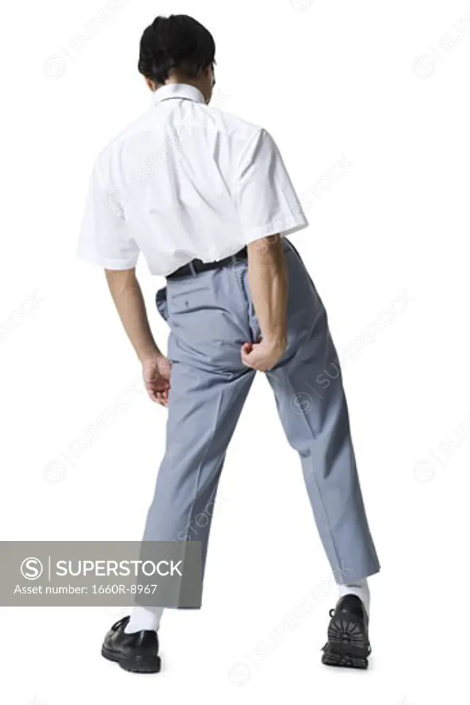 Rear view of a young man adjusting his pants