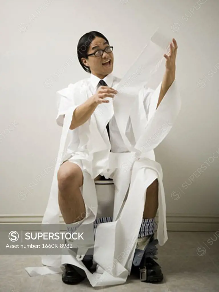 Close-up of a young man sitting on a toilet