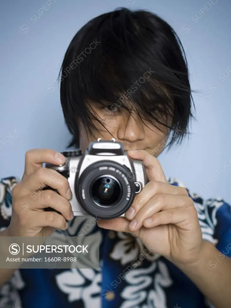 Portrait of a young man taking a photograph with a camera