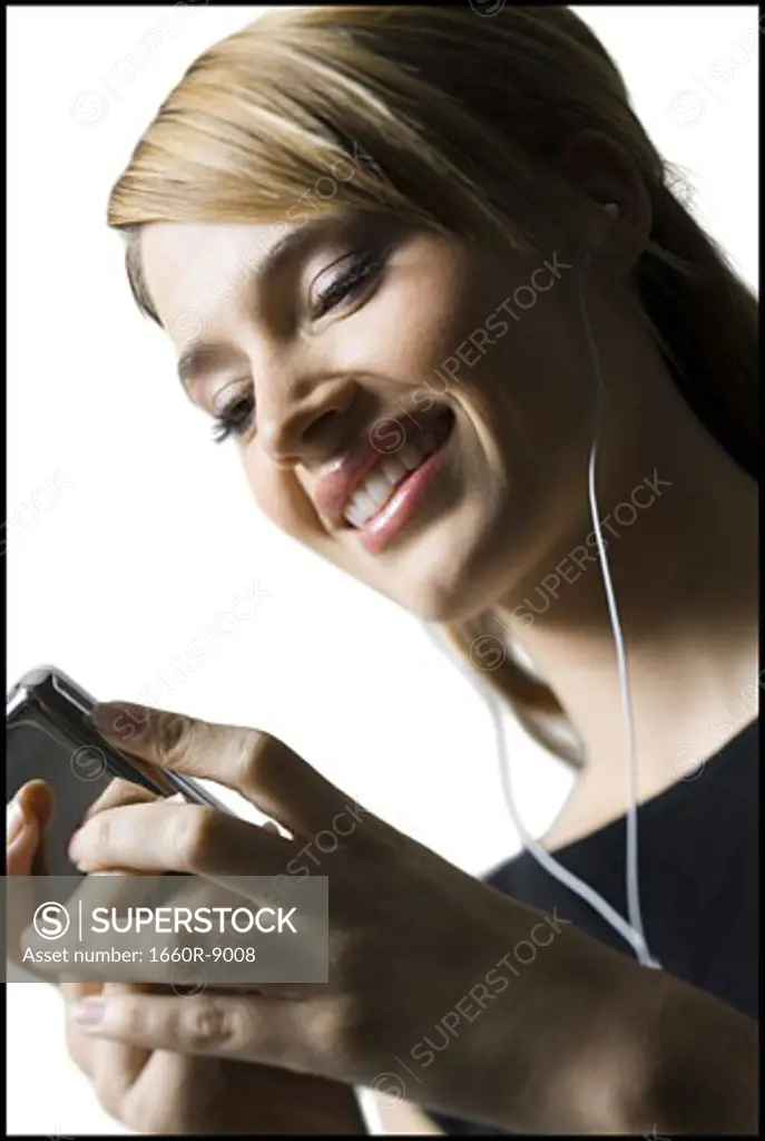 Low angle view of a young woman listening to an MP3 player