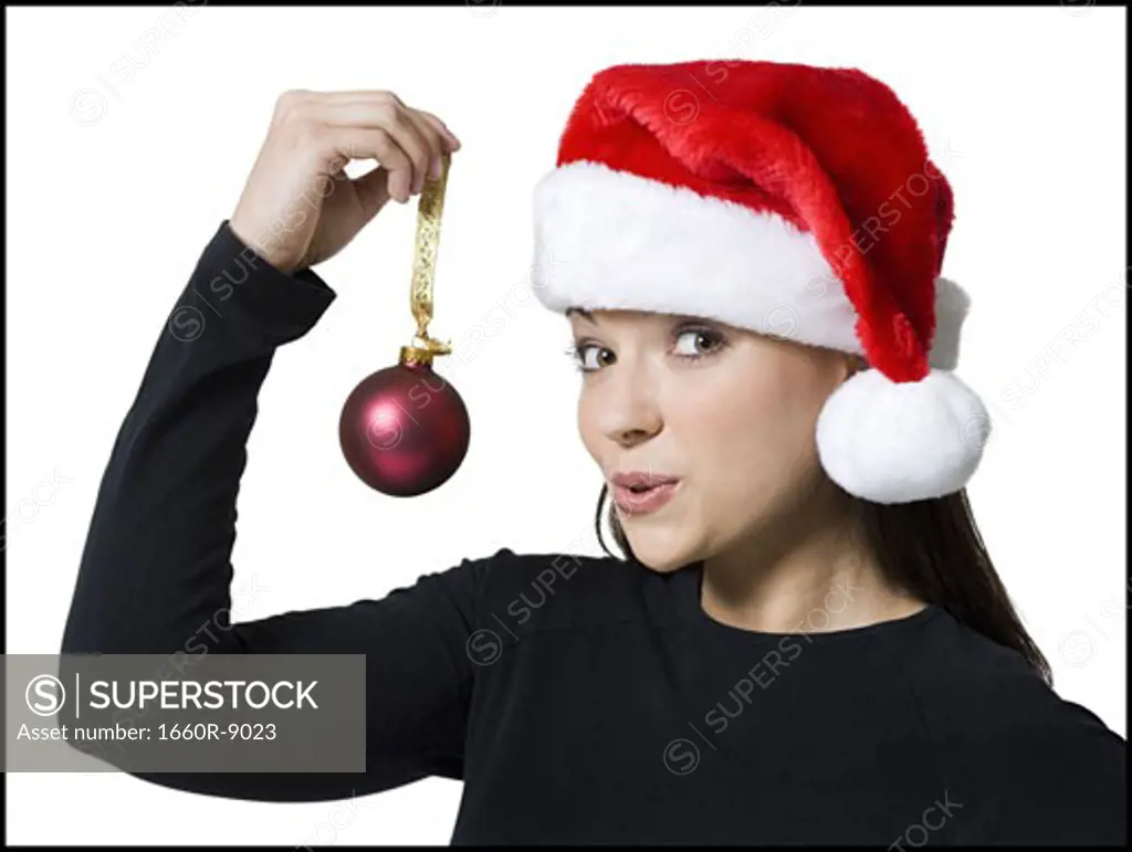 Portrait of a young woman holding a Christmas ornament