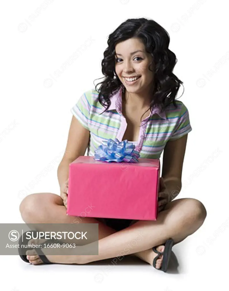 Portrait of a teenage girl holding a gift box