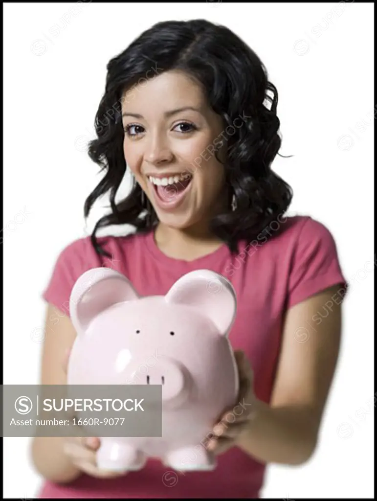Portrait of a teenage girl holding a piggy bank