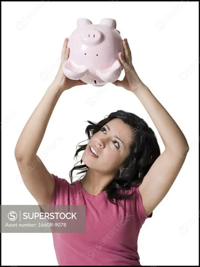 A girl shaking a piggy bank upside down