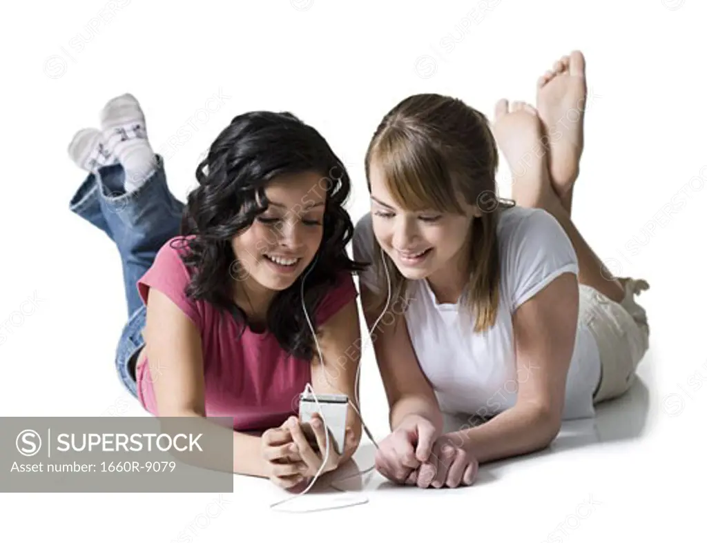 Close-up of two girls listening to music on an MP3 player