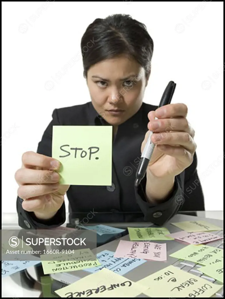 Portrait of a businesswoman holding a note and a felt tip pen