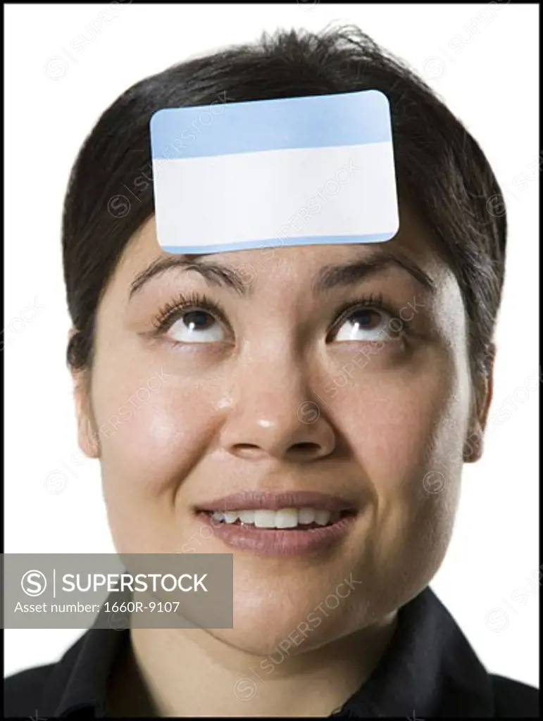 Close-up of a young woman with a blank name tag on her forehead