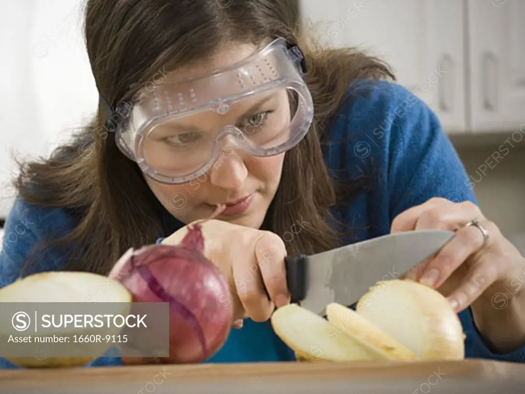Close-up of a mid adult woman cutting an onion