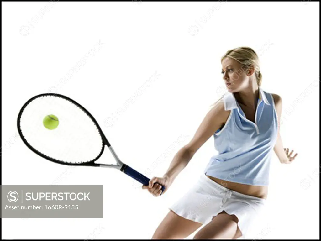 Low angle view of a young woman playing tennis
