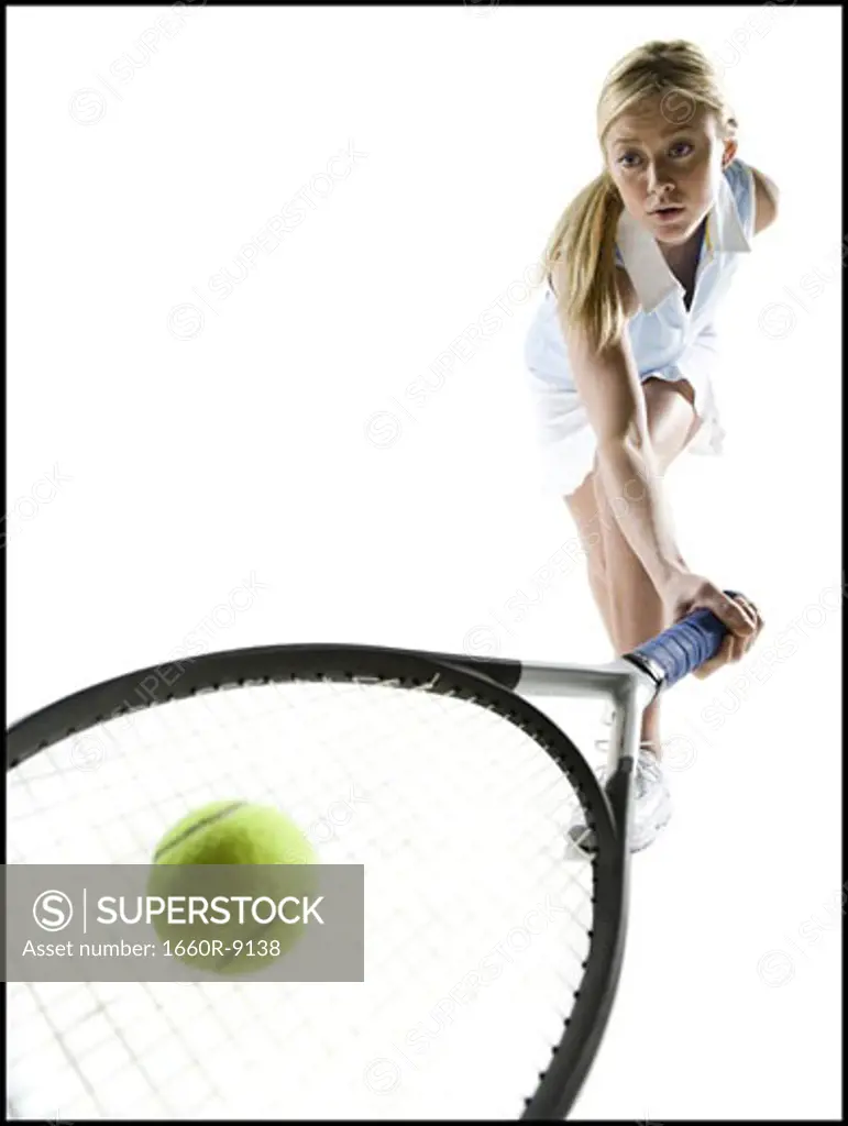Close-up of a young woman hitting a tennis ball