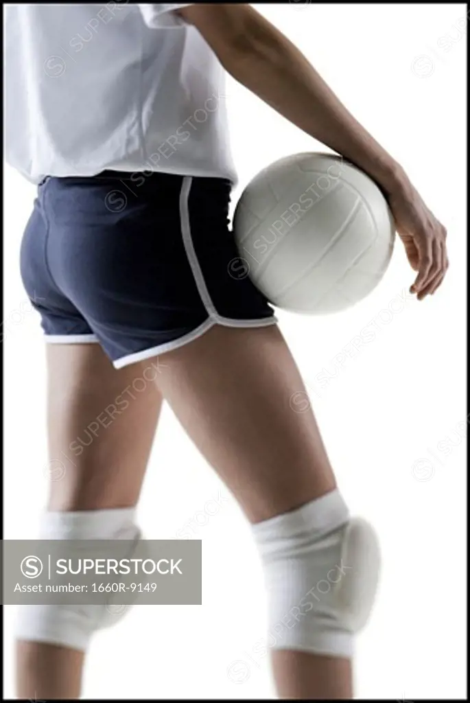 Mid section view of a young woman holding a volleyball