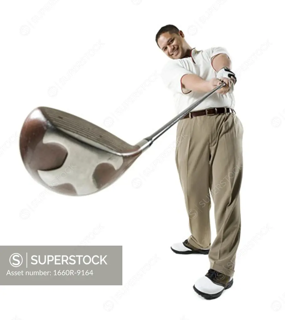 Mid adult man swinging a golf club
