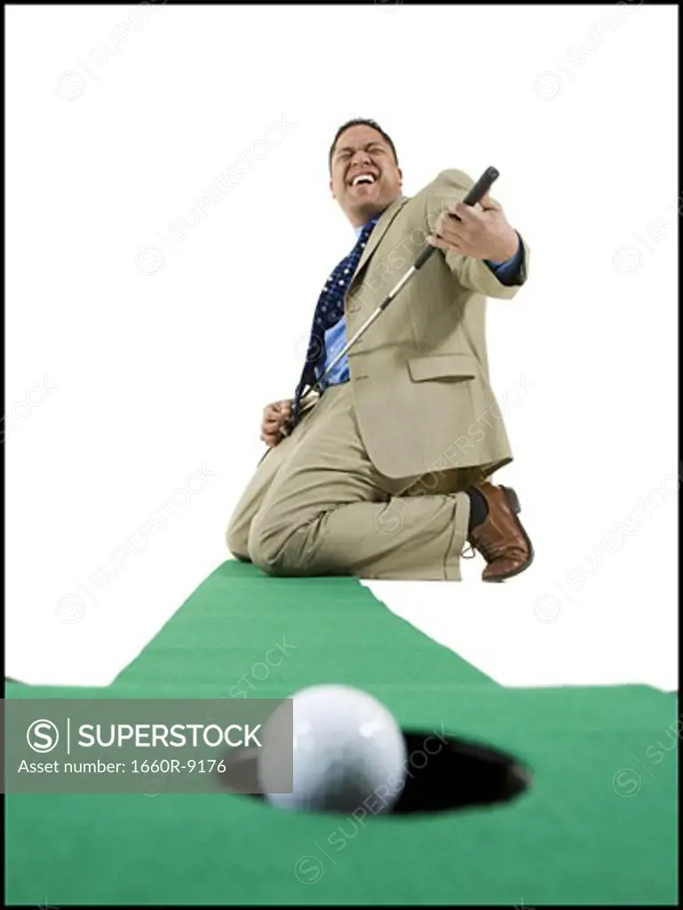 Businessman playing golf on artificial turf