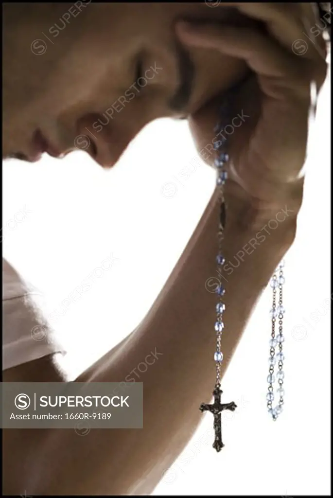 Close-up of a young man holding a crucifix