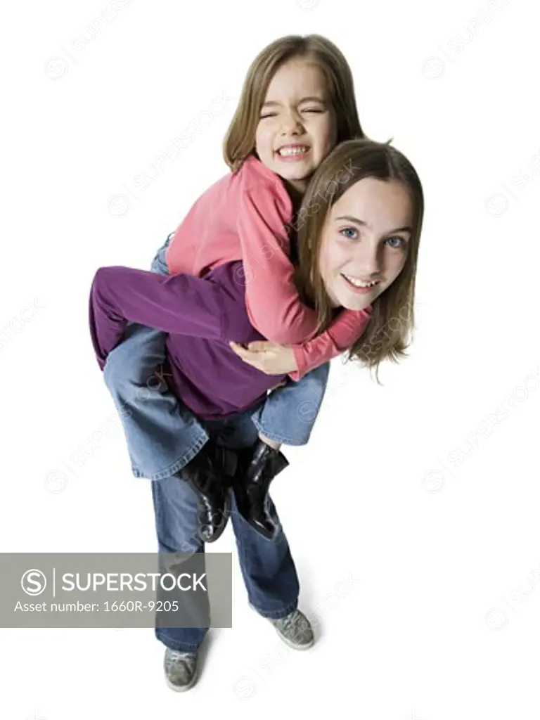 High angle view of a girl riding piggyback on her sister